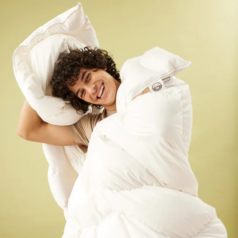 A person wrapped in a white Bonny quilt